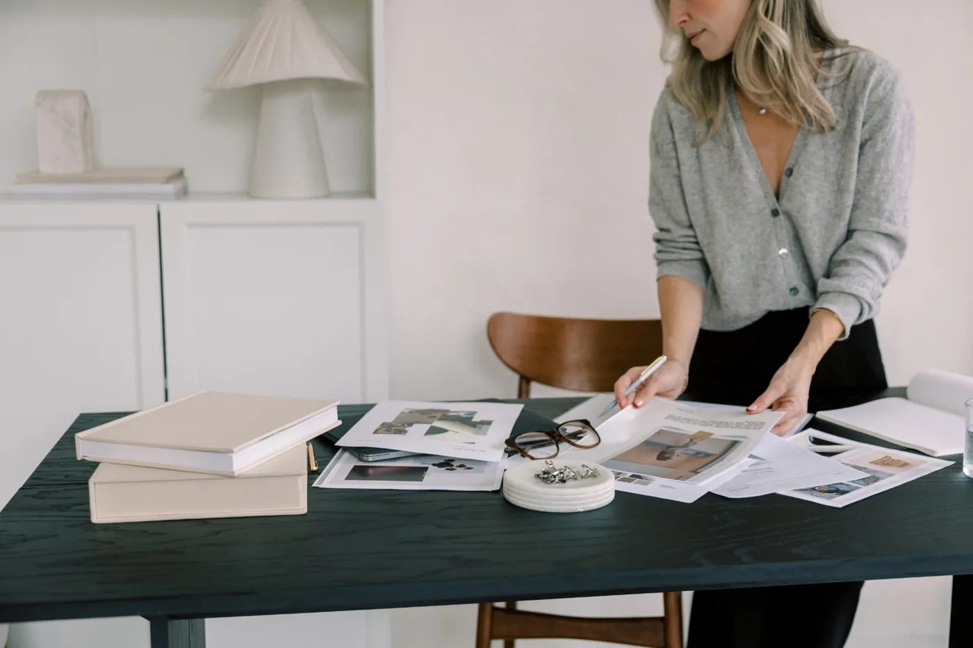 A woman mapping out her plans at a table spread with notes and books